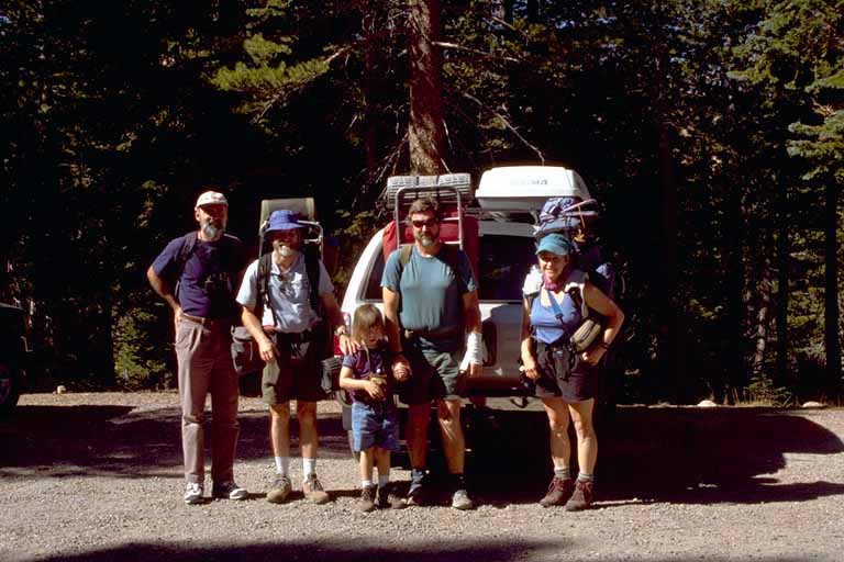 photo, group shot of four adults and one child in front of a Toyota four-runner