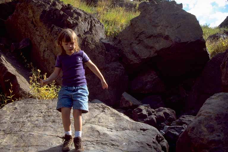 photo, kid climbing on boulders in creekbed