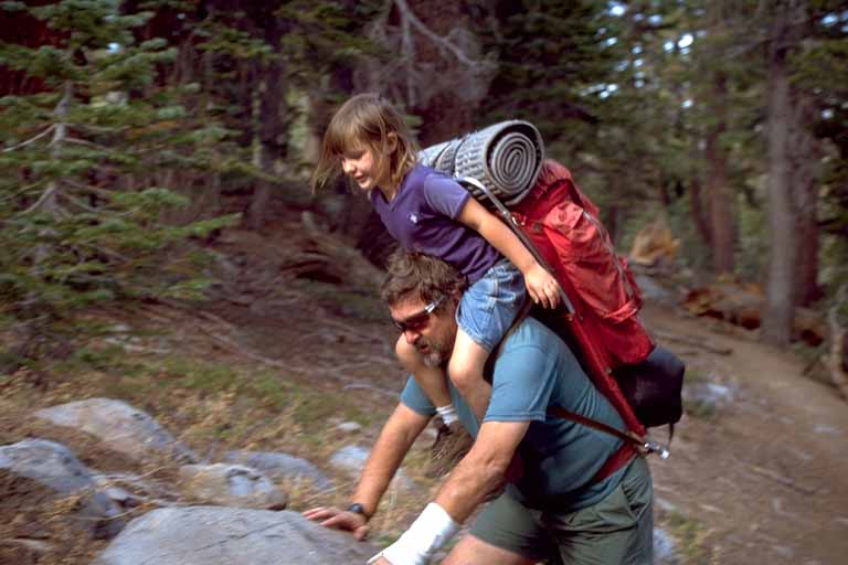 photo, dad with large pack adding daughter on his shoulders