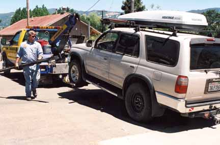 photo of tow truck hauling Toyota Four Runner away