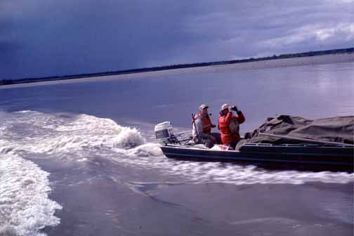 photo, Bill at the tiller as boat speeds along lake